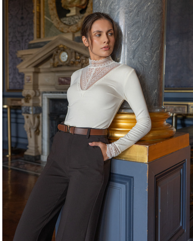 Louna-pitsikoristeinen kerman värinen korkeakauluksinen pusero. 