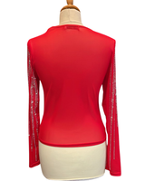 Punainen elegantti läpikuultava pusero strassikoristeilla.