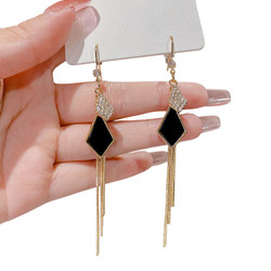 Kullanväriset roikkuvat korvakorut mustalla kuviolla