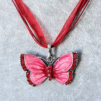 Kimalteleva punainen emaloitu perhonen kaulakoru