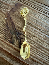 Lusikka kultaisen värinen, kippura varrella		