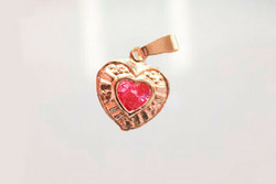 Kultainen sydänriipus vaaleanpunaisella kivellä