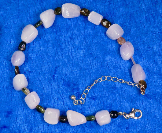 Rannekoru kunziitti, väleissä monen värisiä turmaliineja