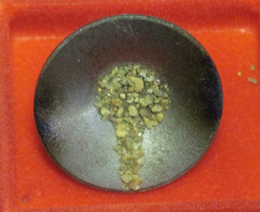 Pinssi vaskooli jossa kullan väristä hiekkaa, metallia