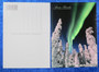 Postikortti Aurora Borealis. Vihreät revontulet ja tykkylumiset puut