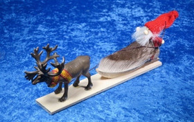 Joulukoriste poro vetää joulupukkia pulkassa