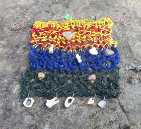 Seinäkoriste lapin kiviä, poron hammas, poronluita, puuta. Nro RM