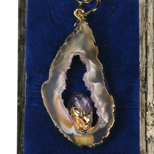 Riipus akaattisiivu, jonka keskellä ametistikide nro AMK7