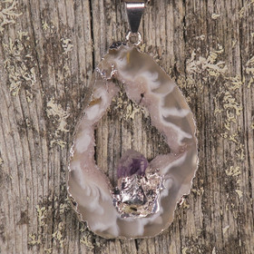 Riipus akaattisiivu, jonka keskellä ametistikide nro AKAM27