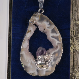 Riipus akaattisiivu, jonka keskellä ametistikide nro AKAM27