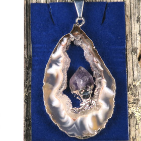 Riipus akaattisiivu, jonka keskellä ametistikide nro AKAM58