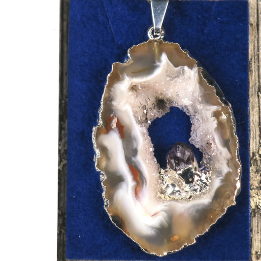 Riipus akaattisiivu, jonka keskellä ametistikide nro AKAM60