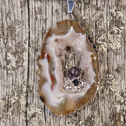 Riipus akaattisiivu, jonka keskellä ametistikide nro AKAM60