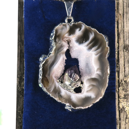 Riipus akaattisiivu, jonka keskellä ametistikide nro AKAM70