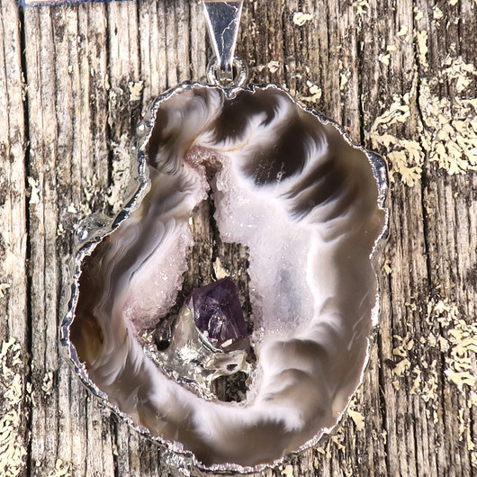 Riipus akaattisiivu, jonka keskellä ametistikide nro AKAM70