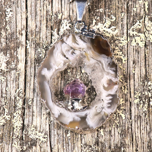 Riipus akaattisiivu, jonka keskellä ametistikide nro AKAM83