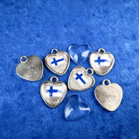 Sydän suurentavalla linssillä, metallia. Askartelutarvike.