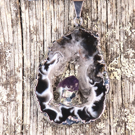 Riipus akaattisiivu, jonka keskellä ametistikide nro AKAM84