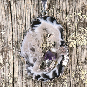 Riipus akaattisiivu, jonka keskellä ametistikide nro AKAM85