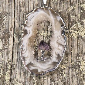 Riipus akaattisiivu, jonka keskellä ametistikide nro AKAM50