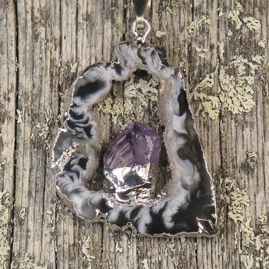 Riipus akaattisiivu, jonka keskellä ametistikide nro AKAM49