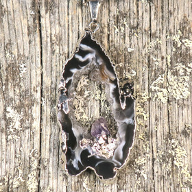 Riipus akaattisiivu, jonka keskellä ametistikide nro AKAM48