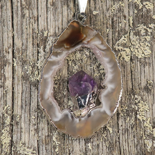 Riipus akaattisiivu, jonka keskellä ametistikide nro AKAM47