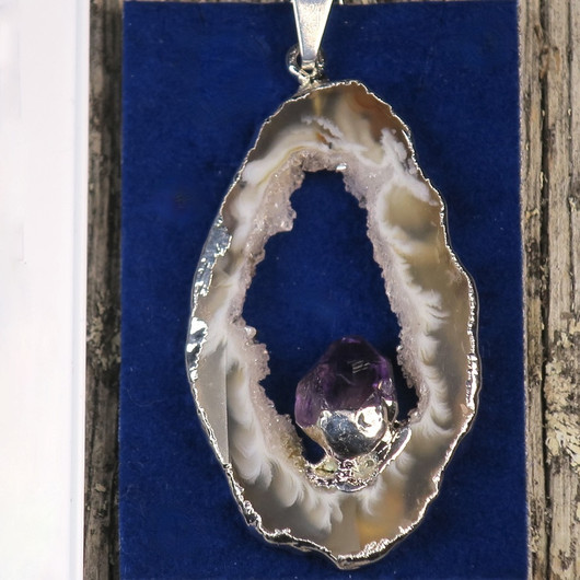 Riipus akaattisiivu, jonka keskellä ametistikide nro AKAM46