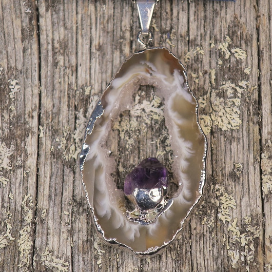 Riipus akaattisiivu, jonka keskellä ametistikide nro AKAM46