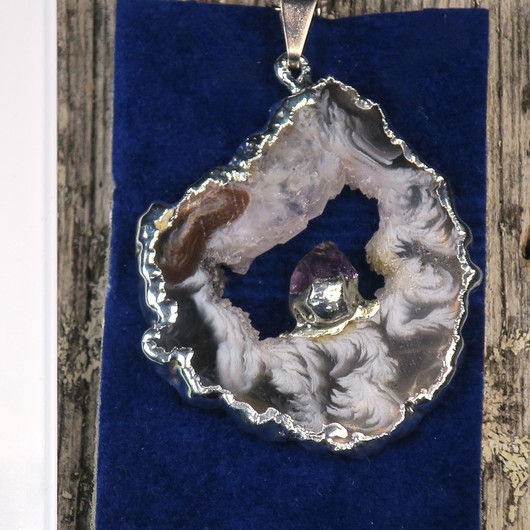 Riipus akaattisiivu, jonka keskellä ametistikide nro AKAM45