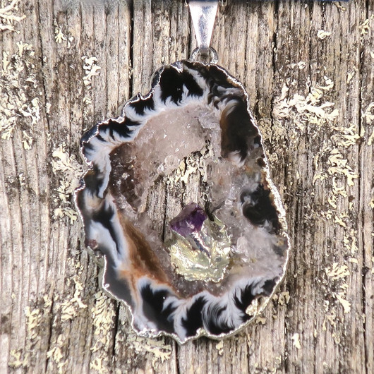 Riipus akaattisiivu, jonka keskellä ametistikide nro AKAM44