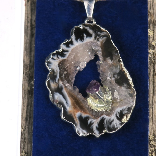 Riipus akaattisiivu, jonka keskellä ametistikide nro AKAM44