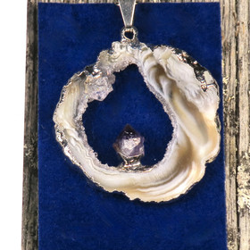 Riipus akaattisiivu, jonka keskellä ametistikide nro AKAM43