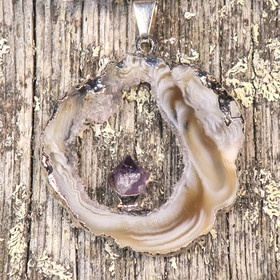 Riipus akaattisiivu, jonka keskellä ametistikide nro AKAM43