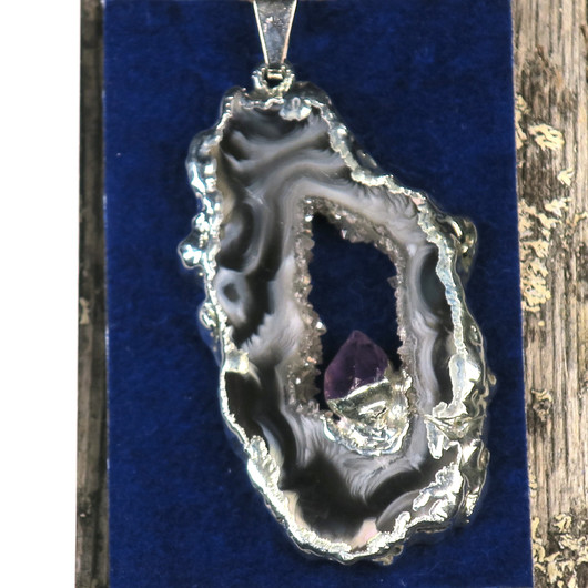 Riipus akaattisiivu, jonka keskellä ametistikide nro AKAM42