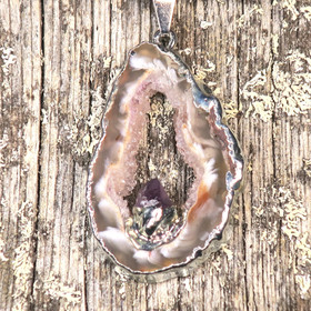 Riipus akaattisiivu, jonka keskellä ametistikide nro AKAM41