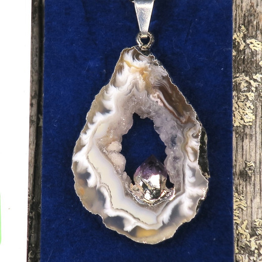 Riipus akaattisiivu, jonka keskellä ametistikide nro AKAM40