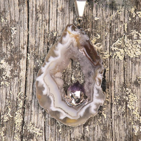 Riipus akaattisiivu, jonka keskellä ametistikide nro AKAM40