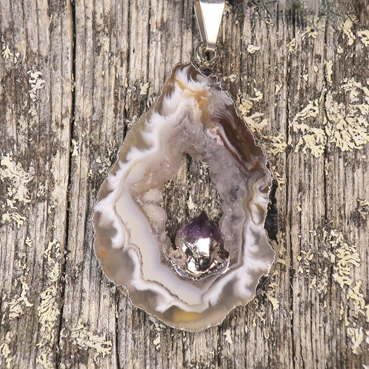 Riipus akaattisiivu, jonka keskellä ametistikide nro AKAM40