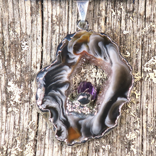 Riipus akaattisiivu, jonka keskellä ametistikide nro AKAM39