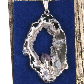 Riipus akaattisiivu, jonka keskellä ametistikide nro AKAM38