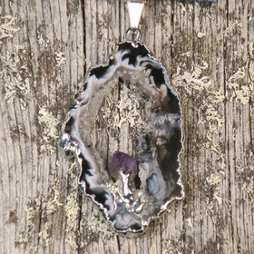 Riipus akaattisiivu, jonka keskellä ametistikide nro AKAM38