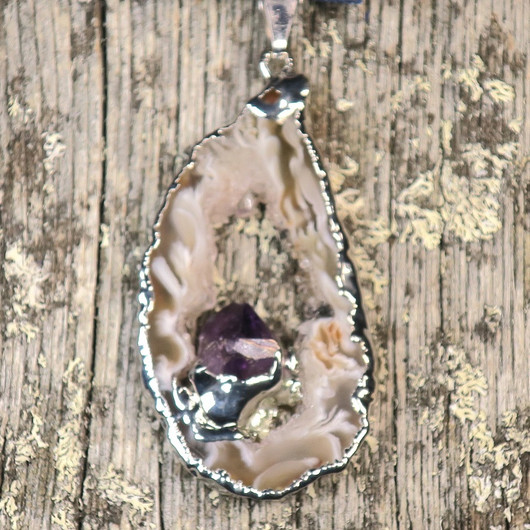 Riipus akaattisiivu, jonka keskellä ametistikide nro AKAM37