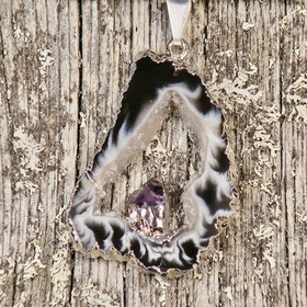 Riipus akaattisiivu, jonka keskellä ametistikide nro AKAM36