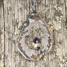 Riipus akaattisiivu, jonka keskellä ametistikide nro AKAM35