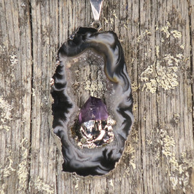 Riipus akaattisiivu, jonka keskellä ametistikide nro AKAM34