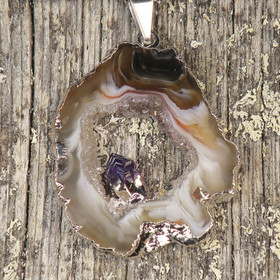 Riipus akaattisiivu, jonka keskellä ametistikide nro AKAM33