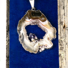 Riipus akaattisiivu, jonka keskellä ametistikide nro AKAM33