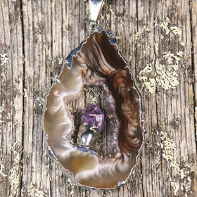 Riipus akaattisiivu, jonka keskellä ametistikide nro AKAM31