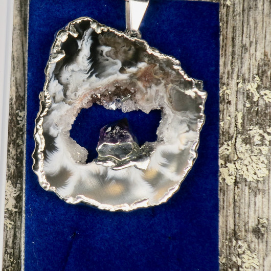 Riipus akaattisiivu, jonka keskellä ametistikide nro AKAM30